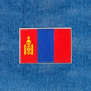 May include: A rectangular patch featuring the flag of Mongolia. The flag has three vertical stripes: two red outer stripes and a blue center stripe. A yellow Soyombo symbol is on the left red stripe. The patch is on a blue denim background.