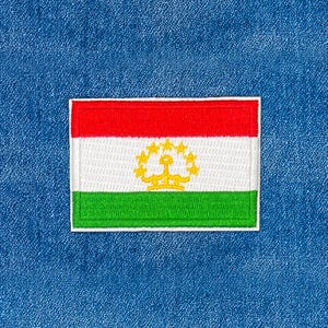 May include: Embroidered rectangular patch depicting the flag of Tajikistan. The flag has horizontal stripes of red, white, and green, with a gold emblem on the white stripe. The patch is edged with white and set against a blue denim backdrop.