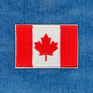 Peut inclure: Un écusson rectangulaire brodé représentant le drapeau canadien avec une feuille d'érable rouge centrale sur fond blanc, encadrée par deux bandes verticales rouges. La broderie présente une texture cousue et une bordure nette.