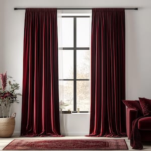 Könnte beinhalten: Zwei tiefrote Samtvorhänge hängen an einem Fenster mit einer schwarzen Gardinenstange. Die Vorhänge sind vollständig zugezogen und das Fenster ist durch einen weißen Schleier sichtbar.