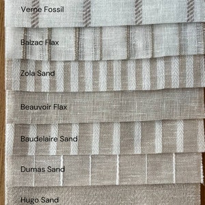 K&ouml;nnte beinhalten: Nahaufnahme von zehn Stoffmustern in verschiedenen Beige- und Wei&szlig;t&ouml;nen mit unterschiedlichen Texturen und Mustern. Die Muster sind mit Namen wie "Proust Sand", "Verne Fossil", "Balzac Flax" und "Zola Sand" beschriftet.