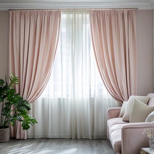 Könnte beinhalten: Ein Fenster mit transparenten weißen Vorhängen und weichen, rosafarbenen Samtvorhängen. Die Vorhänge sind zurückgezogen und geben den Blick auf ein helles Fenster frei. Ein rosa Sofa mit weißen Kissen und eine Topfpflanze befinden sich im Raum.