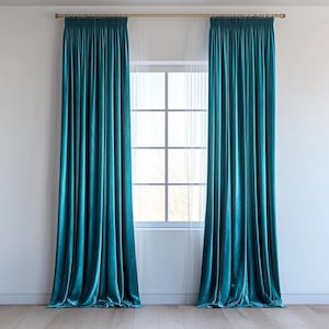May include: A pair of teal velvet curtains hang in front of a window with white sheer curtains. The curtains are closed and the room is well-lit.