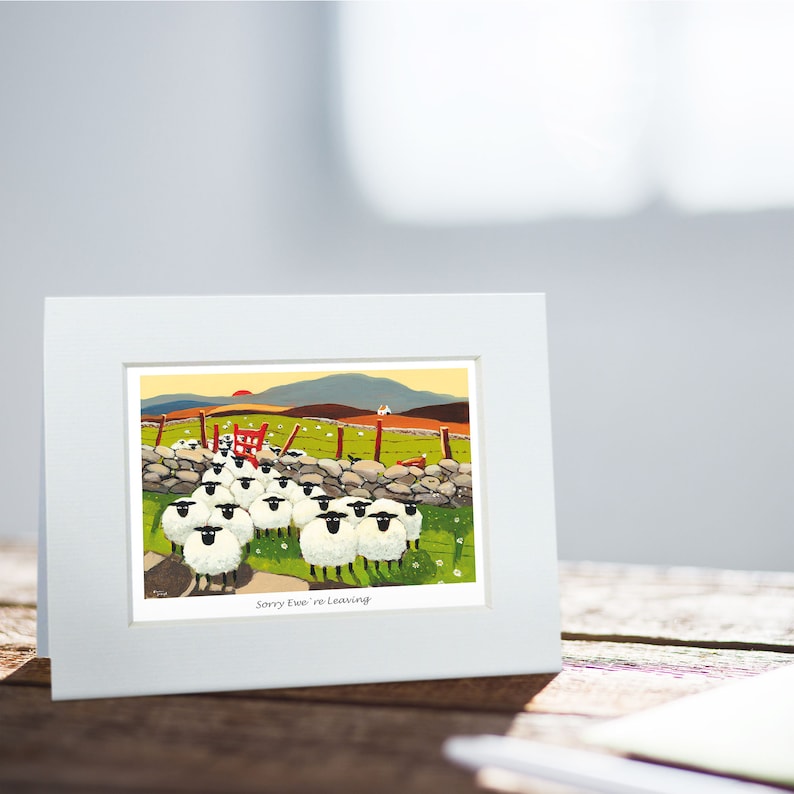 May include: A white framed card with a colorful illustration of a flock of sheep walking away from a red gate. The text "Sorry Ewe're Leaving" is printed below the image.