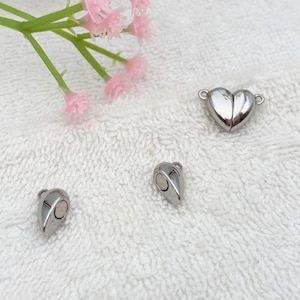 May include: Three silver magnetic clasps for jewelry making. One clasp is a heart shape, and the other two are teardrop shapes.