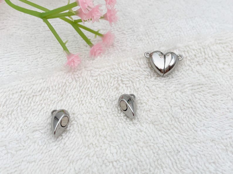 May include: Three silver magnetic clasps for jewelry making. One clasp is a heart shape, and the other two are teardrop shapes.