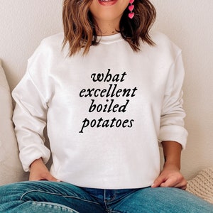 Op de afbeelding: Wit sweatshirt met de tekst "what excellent boiled potatoes" in zwart gedrukt.