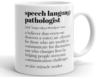 Op de afbeelding: Een witte keramische mok met een zwart-wit ontwerp. De mok heeft een definitie van de term "logopedist" met de fonetische uitspraak en een beschrijving van de rol. De tekst luidt: "logopedist [spit længwads pə'balədəst] zelfstandig naamwoord. iemand die gelooft dat iedereen een stem verdient; een advocaat voor degenen die niet in staat zijn om voor zichzelf te communiceren; iemand die levens verandert door mensen te helpen communicatie-uitdagingen te overwinnen zie ook: wonderdoener"