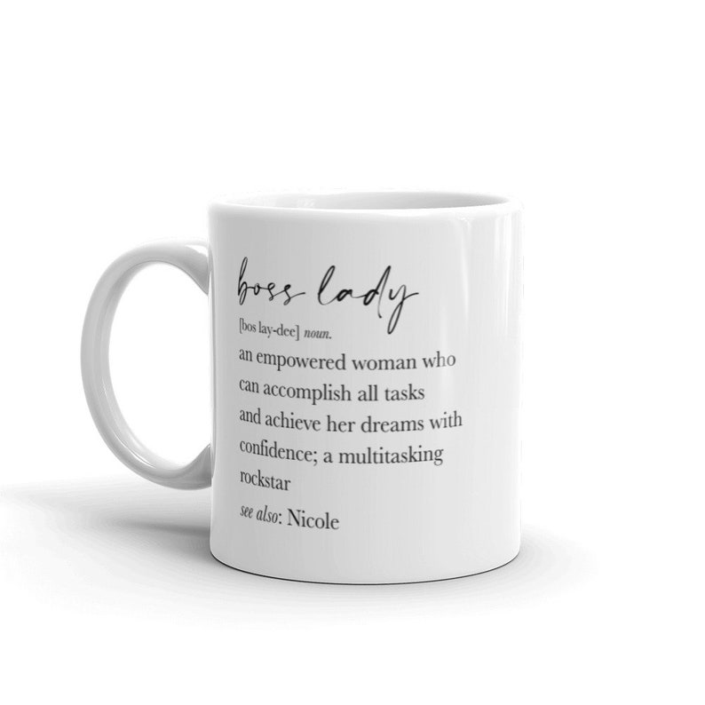 May include: White ceramic mug featuring the words "boss lady" in elegant script. The mug includes a definition of "boss lady", describing an empowered woman. A thoughtful gift for a confident individual.