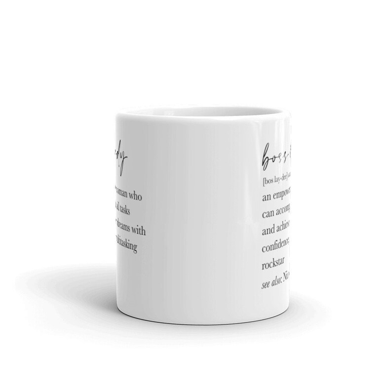 May include: White ceramic mug with the words "lady" and "boss" printed in black script. The mug features definitions of both words. A stylish and inspirational gift.