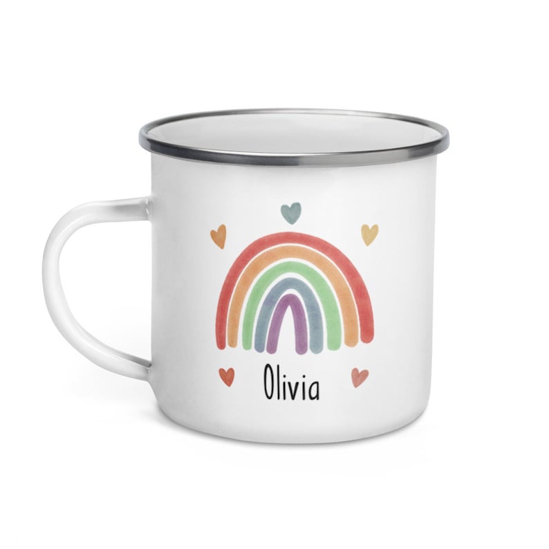 May include: White enamel mug with a rainbow design and the name Olivia printed below. The rainbow is made up of red, orange, yellow, green, blue, indigo, and violet. There are five small hearts around the rainbow.