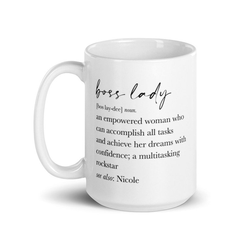 May include: White ceramic mug featuring the words "boss lady" in elegant script. The mug includes a definition of "boss lady" and the text "see also: Nicole". A great gift for an empowered woman.