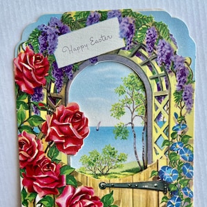 Carte de Pâques idyllique avec un arc couvert de roses mer et hollyhocks.