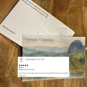 May include: Two postcards, one white with text and the hashtag #ThePacks2025, and another with a landscape of Guatap&eacute;, Colombia. A customer review is visible, mentioning the quantity of 50 and a UV high gloss finish.