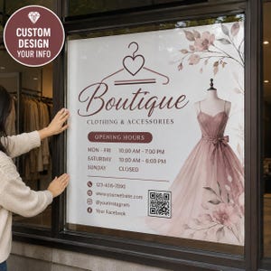 May include: A window decal for a clothing boutique featuring a heart-shaped hanger icon, the text Boutique CLOTHING & ACCESSORIES, opening hours, contact details, a QR code, and an illustration of a dusty rose gown with floral accents.