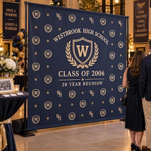 May include: A large navy blue step and repeat backdrop banner featuring a repeating gold pattern of the letter W inside a shield and stars. The center displays the text Westbrook High School, Class of 2006, and 20 Year Reunion in gold.