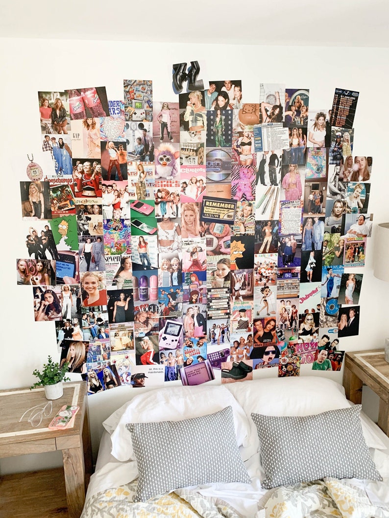 May include: A white wall covered in a collage of photos and magazine clippings from the 1990s and early 2000s. The collage includes images of celebrities, fashion, and pop culture icons. The collage is above a bed with white bedding and two grey pillows.
