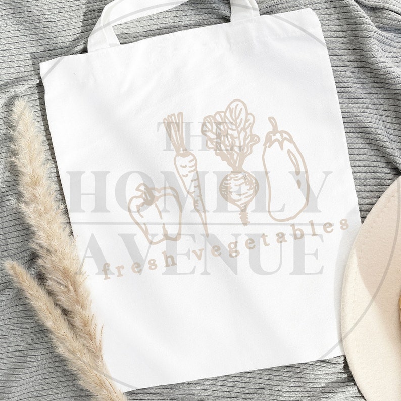 May include: White tote bag with a brown outline of vegetables and the text "The Homely Avenue Fresh Vegetables".