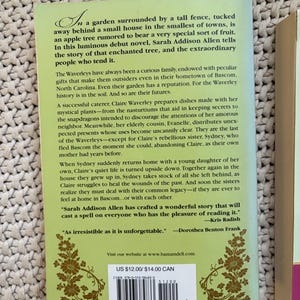 May include: A book cover with a green background and floral design. The title and author's name are not visible. The back cover text describes a novel about a family with peculiar gifts and an enchanted tree. The price is $12.00.