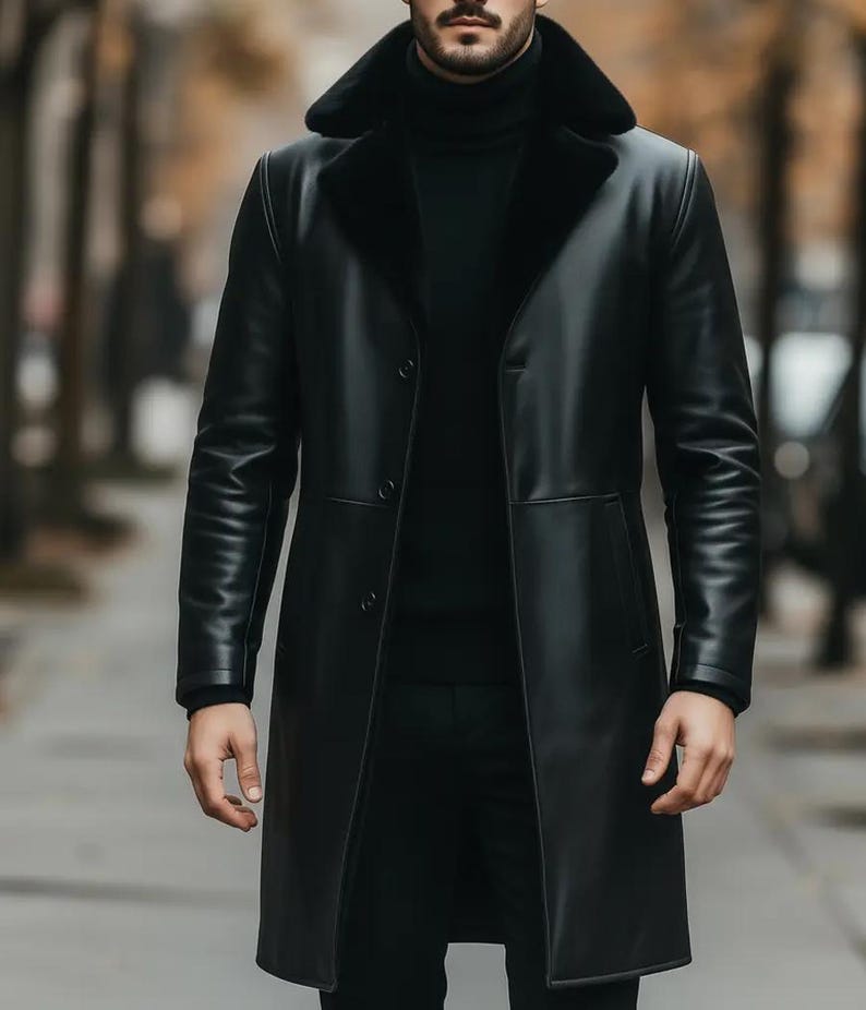 May include: A long, black leather coat with a shearling collar. The coat has a button-up front and is worn over a black turtleneck. The sleeves are long and the coat reaches the knees. The coat is a classic style.