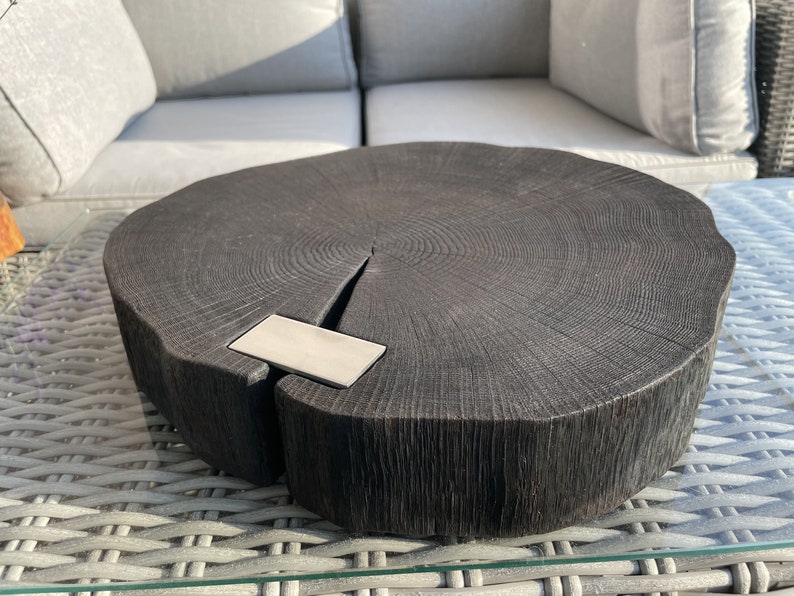May include: A dark wood serving tray with a natural edge and a metal inlay. The tray is round and has a rustic look.