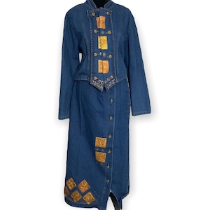 Könnte beinhalten: Ein Jeanskleid mit langem Rock und einem Oberteil im Jackenstil. Das Kleid hat goldene Stickereien auf der Vorderseite und Knöpfe an der Vorderseite.