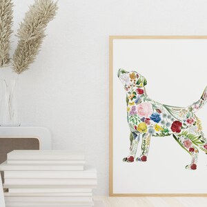 May include: A framed art print featuring a dog silhouette filled with colorful flowers. The artwork has a white background and a natural wood frame. The flowers include red, pink, yellow, and blue blooms, creating a vibrant and artistic design.