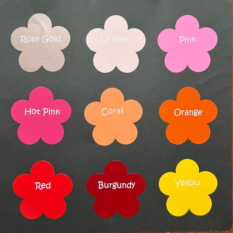 May include: Nine flower-shaped paper samples in different colors, including rose gold, light pink, pink, hot pink, coral, orange, red, burgundy, and yellow.