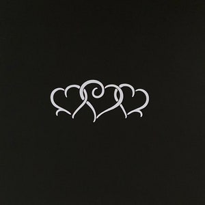 May include: Three white hearts intertwined in a decorative design on a black background.