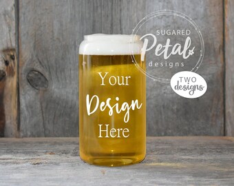 May include: A clear glass with a frosted rim filled with a light yellow beverage. The glass has the text "Your Design Here" printed on the side. The glass is sitting on a wooden surface.