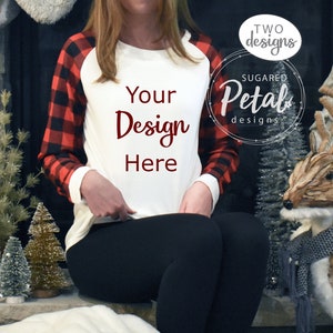 May include: A white long-sleeve shirt with red and black buffalo plaid sleeves. The shirt has a crew neck and a relaxed fit. The text "Your Design Here" is printed on the front of the shirt in maroon.