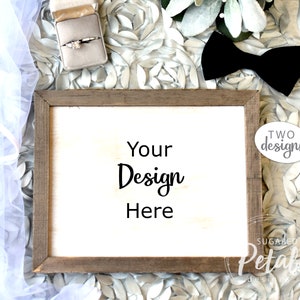 May include: A white wooden sign with a brown frame, sitting on a white and silver background. The sign says "Your Design Here".