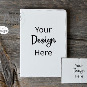 May include: Two white blank notebooks with the text "Your Design Here" on the front. The notebooks are on a wooden surface.