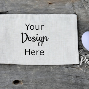 May include: A white canvas zippered pouch with a black strap and the text "Your Design Here". The pouch is on a wooden surface with three pastel colored Easter eggs.