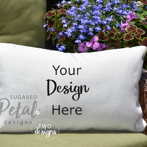 May include: White rectangular pillow with the text "Your Design Here" in black script. The pillow is on a green cushion, with a background of flowers and a wicker chair.