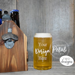May include: A wooden six-pack beer carrier with a bottle opener on the front. A clear glass with a frosted rim and a yellow beverage inside is sitting on a wooden surface. The glass has the text "Your Design Here" printed on it. The text "Sugard Petal Designs" is printed on a white circle behind the glass.