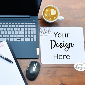 May include: A white desk mat with the text "Your Design Here" on a wooden table with a laptop, a pen, a mouse, and a cup of coffee with latte art.