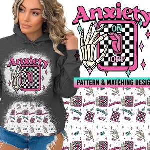 May include: A gray hoodie with a white distressed graphic of a skeleton hand flipping a switch labeled "Anxiety" with the words "ON" and "OFF". The background pattern is a repeating design of the same graphic.