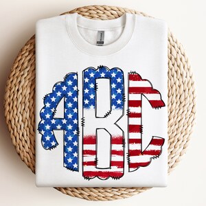 May include: White sweatshirt with a distressed American flag design in the shape of the letters "ABC".