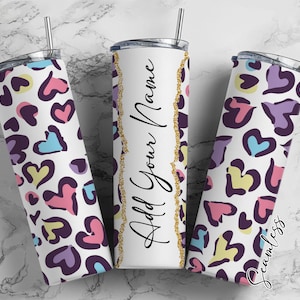 Pode incluir: Três copos de aço inoxidável com fundo branco e um padrão abstrato de corações coloridos. O copo do meio tem o texto "Add Your Name".