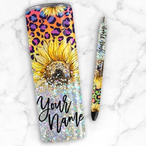 Puede incluir: Un vaso de acero inoxidable con acabado brillante y un dise&ntilde;o de girasoles y estampado de leopardo. El vaso tiene el texto "Your Name".