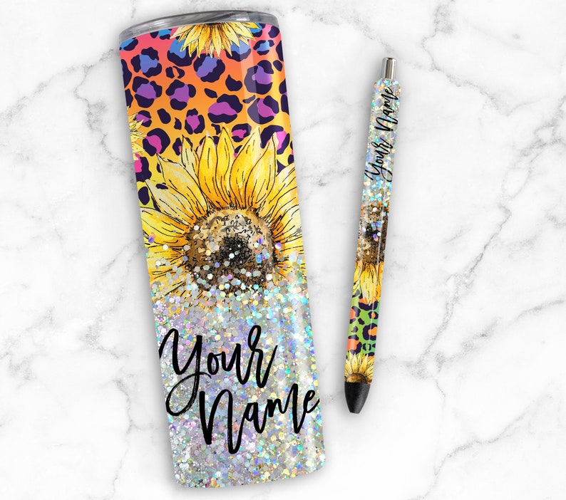 Puede incluir: Un vaso de acero inoxidable con acabado brillante y un dise&ntilde;o de girasoles y estampado de leopardo. El vaso tiene el texto "Your Name".