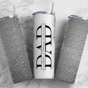 May include: Three stainless steel tumblers with a diamond plate pattern. The center tumbler has the word "DAD" in black text with the words "from tommy & maria" in smaller text below.