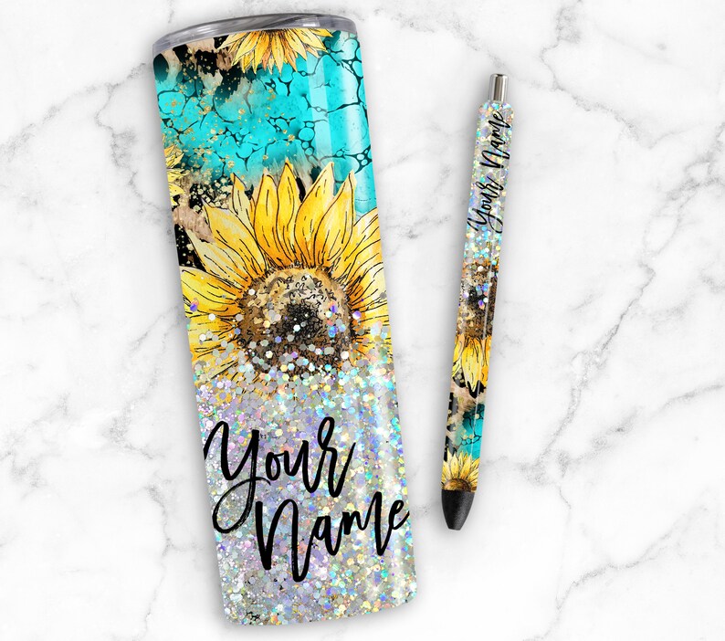 Puede incluir: Un vaso de glitter turquesa y dorado con un dise&ntilde;o de girasol y el texto "Your Name". Tambi&eacute;n se muestra una pluma a juego con el mismo dise&ntilde;o y el texto "Your Name".