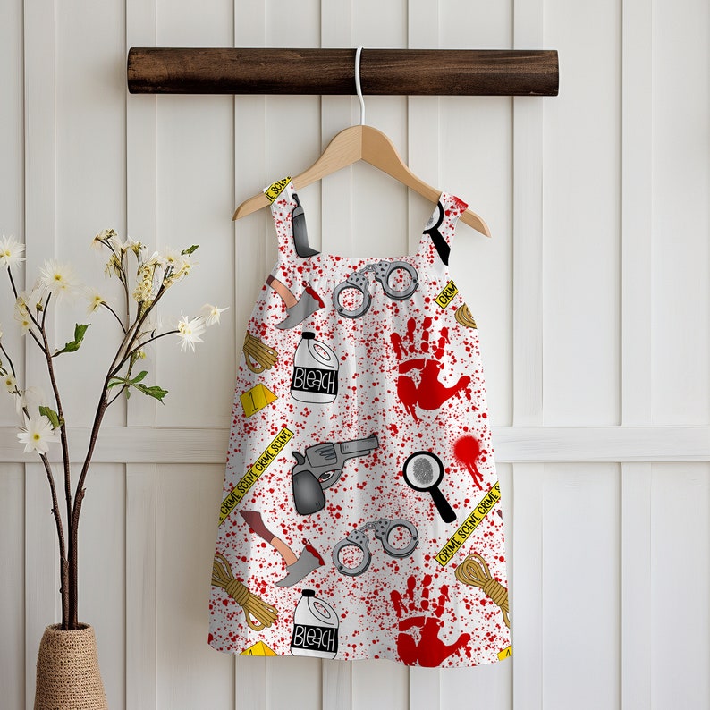 K&ouml;nnte beinhalten: Wei&szlig;es, &auml;rmelloses Kleid mit einem roten und gelben Tatortmuster. Das Muster enth&auml;lt Handschellen, eine Lupe, eine Pistole, eine Flasche Bleichmittel, einen blutigen Handabdruck und den Text "Crime Scene Do Not Cross".
