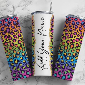 May include: Three stainless steel tumblers with a rainbow leopard print design. The center tumbler is white with the text "Add Your Name" in black.