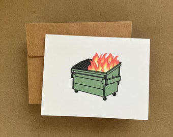 May include: A green wheelie bin with a black lid is on fire. The flames are orange and red.