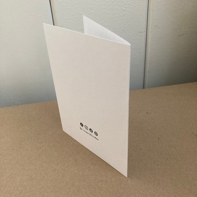 May include: A white card with a blank front and social media icons and the text "@longroadboodies" on the back.