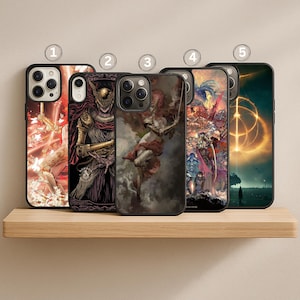 May include: Five black phone cases with different artistic designs are displayed on a wooden shelf. The designs include a figure with wings, a knight in armor, and a fantasy scene with a glowing ring.