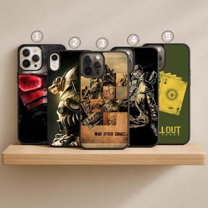 May include: A collection of five black phone cases with various designs. The cases feature images of characters and imagery from the Fallout video game series. The designs include a red helmet, a power armor suit, a collage, a gas mask-wearing figure, and playing cards.